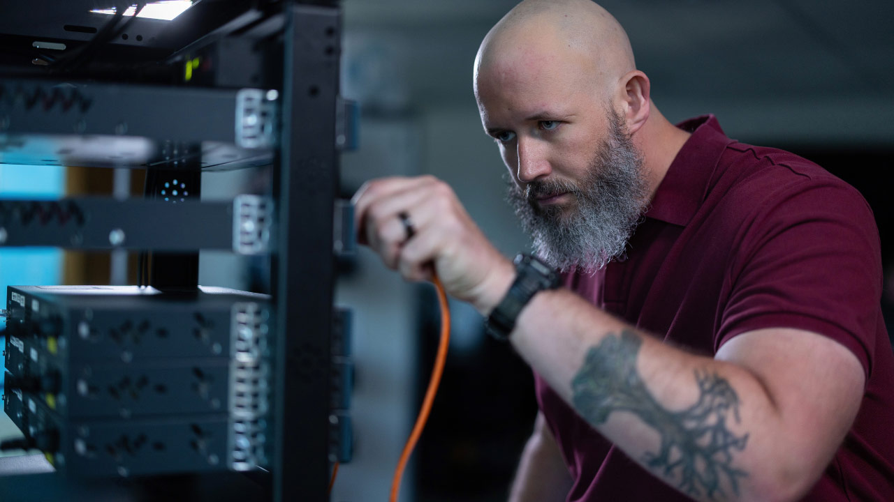 Daniel gaining hands-on experience with network cables in ECPI University’s cybersecurity lab