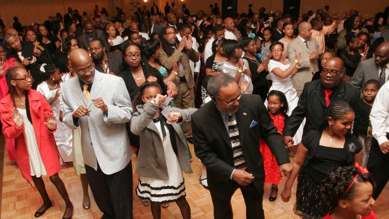 A group of fathers and daughters dancing together at the end of the “Date with Dad