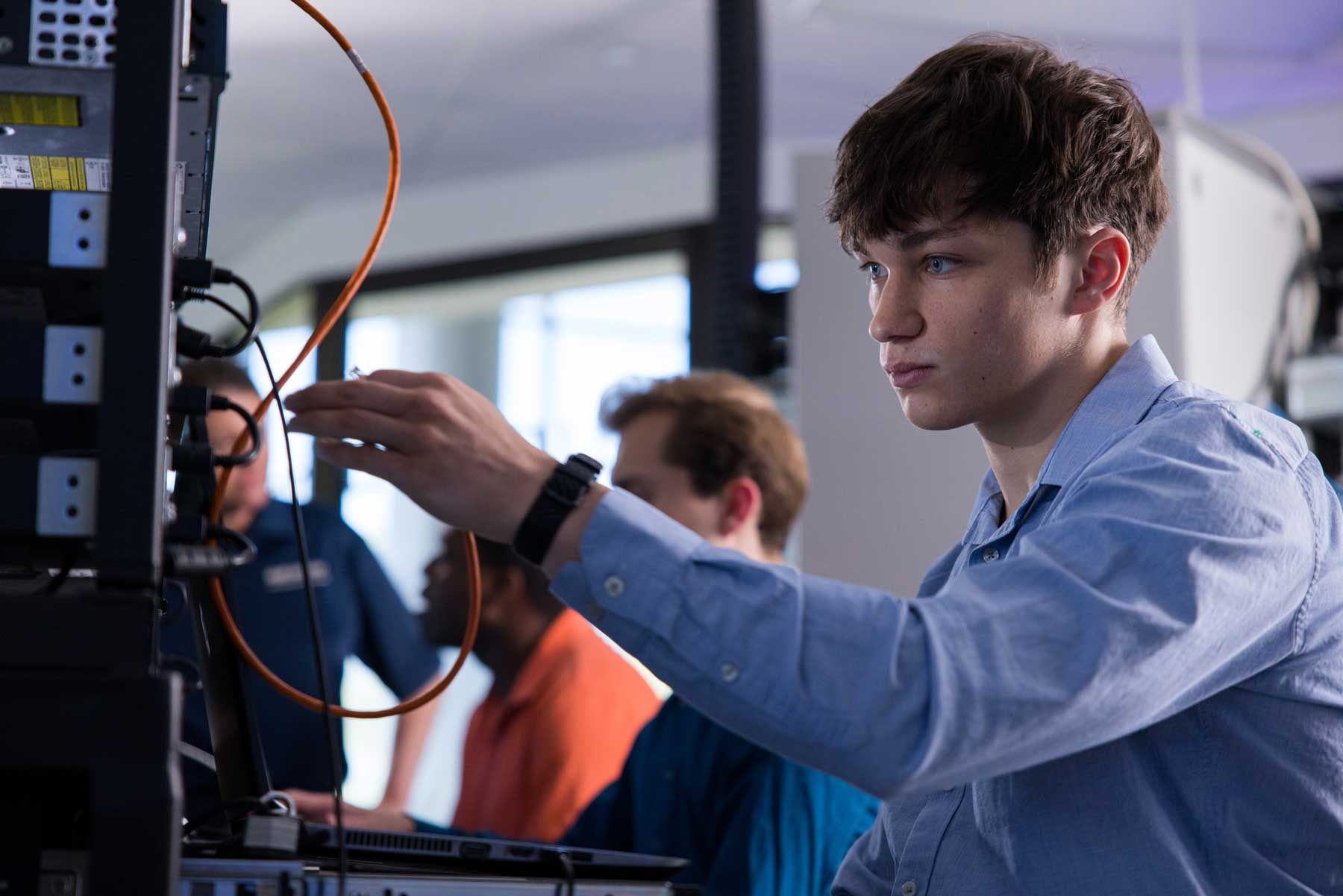 Cybersecurity student working with network equipment