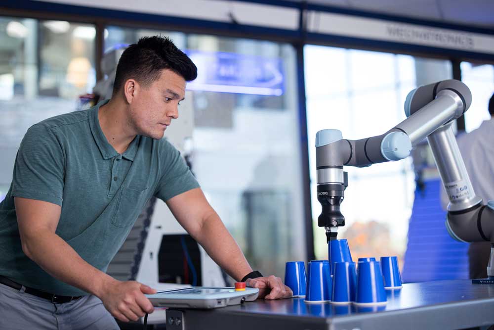 Engineering technology student working with automated equipment