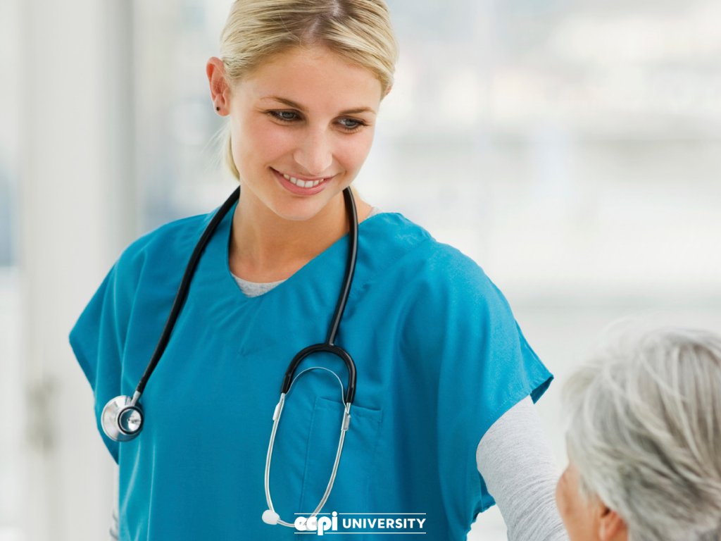 Female nurse in blue scrubs smiling at patient